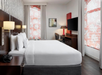 1 King bed, desk, and flat-screen TV in a guest room.