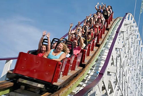 Passengers' hands are up in the air with excitement at the coaster ride.
