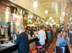 A group of people sitting in the narrow dining area of Eisenbergs on the Flatiron Food, History & Architecture Tour in New York City, NY, USA.