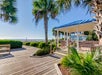 Covered seating area by the boardwalk overlooking the beach.