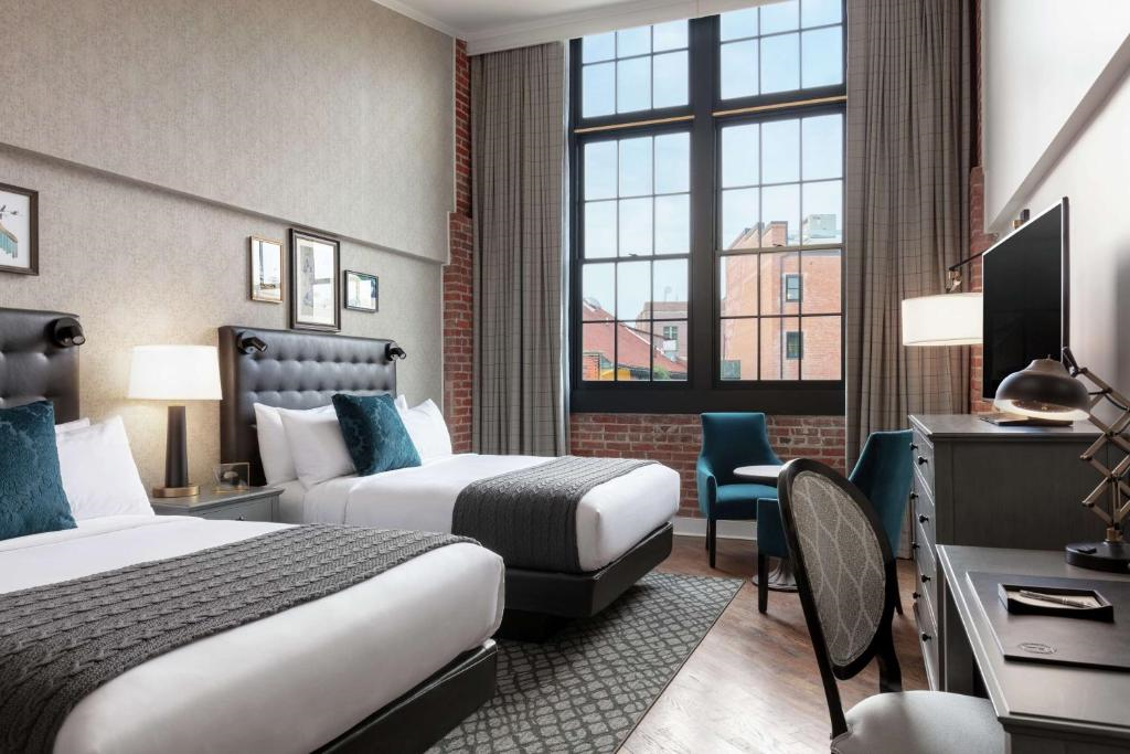 Two queen beds, seating area, a desk and chair, and a flat-screen TV