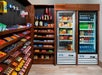 Shelves and refrigerated cases stocked with snacks, candy, frozen meals, bottled drinks, and convenience items in a small retail store or hotel market.