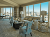 Spacious guest room with seating area and city view.