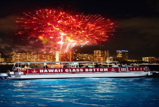 Hawaii Glass Bottom Boat can be seen afloat with the fireworks display.