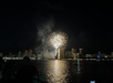 Fireworks being shot on the beach with the city in the background in Waikiki, Hawaii.