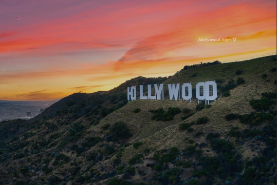 The Hollywood sign is displayed on a hillside at sunset with a colorful sky in the background.