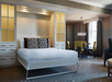 One king bed with plush bedding and a round dining table for four.
