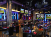 Bar/lounge furnished with black chairs, tables and TVs for entertainment.