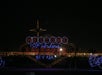 Las Vegas sign illuminated at night, with city lights in the background.