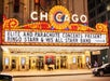 The marquee of the Chicago Theatre advertising a concert by Ringo Starr & His All Starr Band, indicates that the event is presented by Elite and Parachute Concerts and a  lively atmosphere of the city at night.