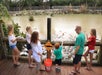A group of family bonding together while feeding the alligators at Everglades Alligator Farm with Go Miami & The Keys Explorer Pass.