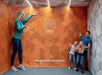 A family having a delightful experience in the Ames Room at the Museum of Illusions.