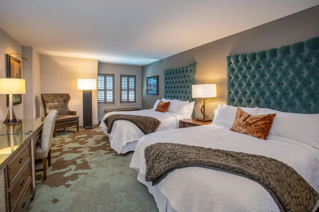 Two queen beds, a desk and a leather armchair