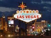 The illuminated "Welcome to Fabulous Las Vegas Nevada" sign stands in front of the city's bright lights and hotels at dusk.