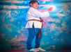 Person dressed in a martial arts costume holding a glowing orb against a cloudy blue and pink backdrop.