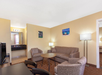 Living area with sofa and chairs inside a guest suite.