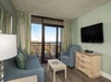 Living room with balcony access and view of the ocean.