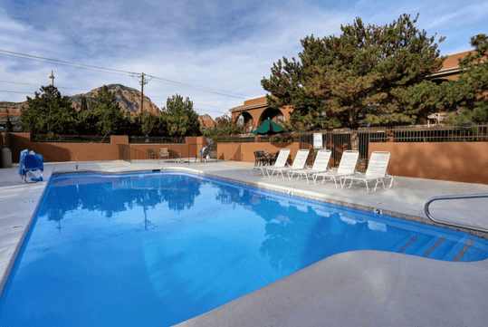 Outdoor pool with sun loungers.
