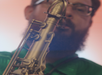 A person playing a saxophone, with the instrument in focus and the background softly blurred.