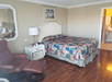 Guest room with 1 king bed and arm chair at Gulfcoast Inn Naples, FL.