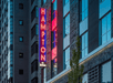 The exterior neon signage saying "HAMPTON" on the side of the Hampton Inn and Suites By Hilton Portland-Pearl District.