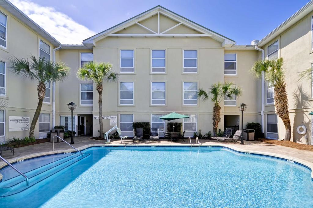 Outdoor pool, an accessible pool lift, chairs and umbrella.