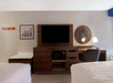 A well-appointed space featuring a TV and dedicated work desk.