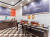 A breakfast area with two countertops full of food and a white and brown checkered floor at the Hampton Inn in Minneapolis, Minnesota.