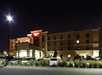 Street view of the the Hampton Inn with a parking lot full of cars on a clear night in Minneapolis, Minnesota.