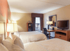 Two queen beds, work desk and a flat-screen TV inside a guest room at Hampton Inn Muskegon, MI.