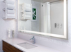 Lighted mirror, vanity, and fresh towels inside a private bathroom.
