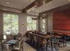 Modern dining area with a long wooden table and high chairs, smaller square tables with chairs, decorative pendant lights, large windows, and a red accent wall.