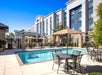 Outdoor pool with poolside chairs, tables, and umbrellas.