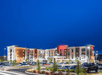 Beautiful landscaped hotel exterior at night.