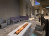 A patio with a large sitting area with a long fire pit in the middle with couches on the far side and tables and chairs in the background.