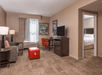 Seating area with a sofa bed, workspace and flat-screen TV at Hampton Inn & Suites Charlotte-Arrowood Rd., NC.