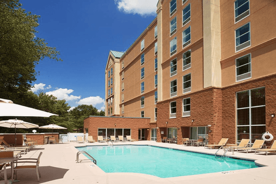 Outdoor pool with sun loungers at Hampton Inn & Suites Charlotte-Arrowood Rd., NC.