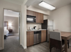 Kitchenette equipped with a stovetop, mini-fridge, microwave, coffee machine and a refrigerator.