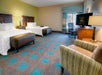 Two Queen beds, a seating area, work desk and chair, and a flat-screen TV.