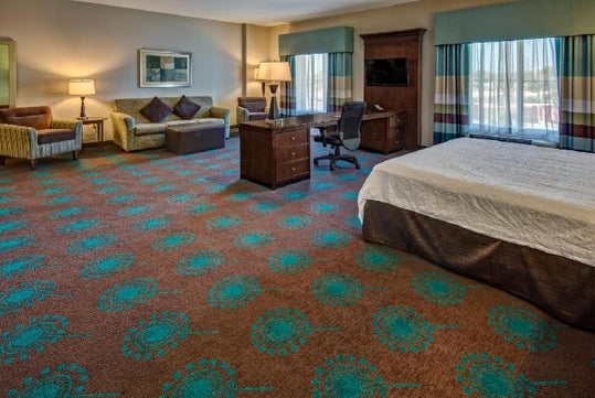 Spacious King room with sofa/seating area, a work desk and chair.