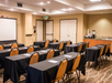 Meeting facility with chairs, long tables, and whiteboard.
