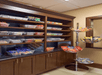 Brown shelves with clear container full of snacks and a tiered snack display at the Hampton Inn & Suites New Braunfels.
