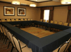 A meeting room with tables net up in a large square with chairs lining the outside at the Hampton Inn & Suites New Braunfels.