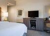 One king bed and flat-screen TV inside a guest room.