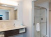 Fresh towels, bathroom amenities and a glass-enclosed shower inside a private bathroom.