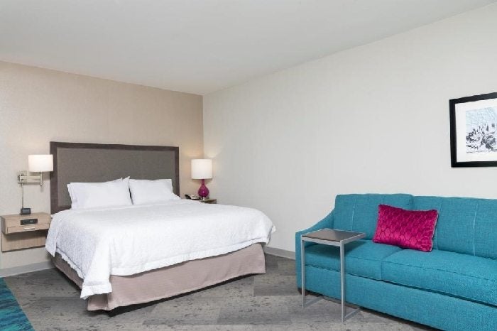 One king bed and a comfortable sofa inside a guest room.
