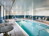 Indoor pool with poolside chairs and pool lift.