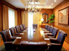 Meeting facility with a long table and multiple chairs.