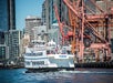 Argosy Cruise boat passing in front of the Cranes at the harbor. Harbor Cruise Seattle Washington.