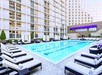 Outdoor pool with sun loungers and cabanas.